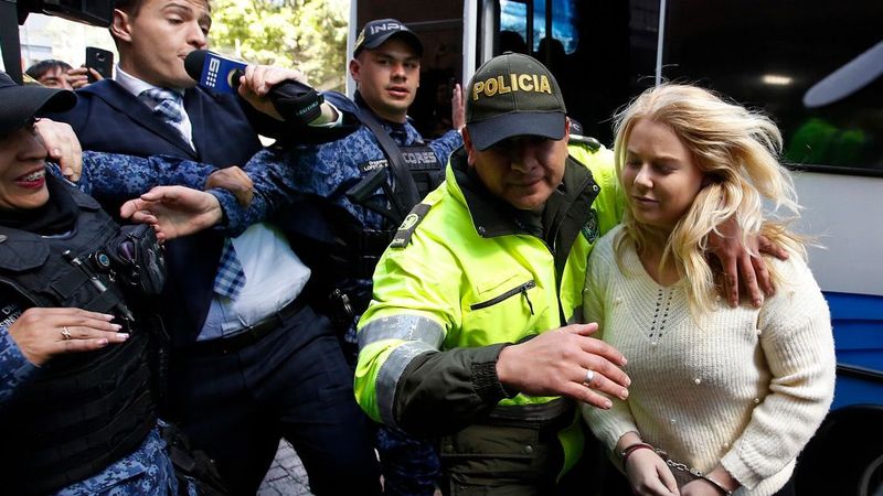 police officer escorts Australian Cassandra Sainsbury to a court hearing in Bogota, Colombia